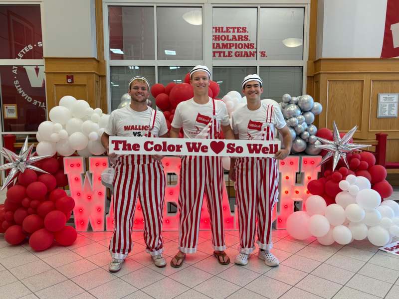 a group of men wearing matching outfits and holding a sign