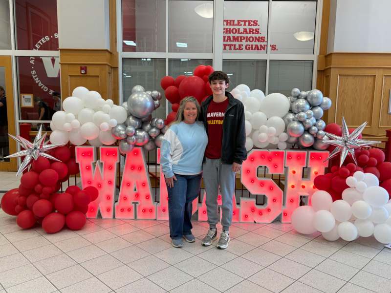 a man and woman standing in front of balloons