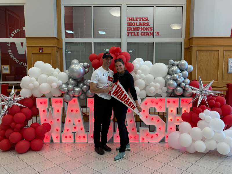 a man and woman posing for a picture in front of balloons