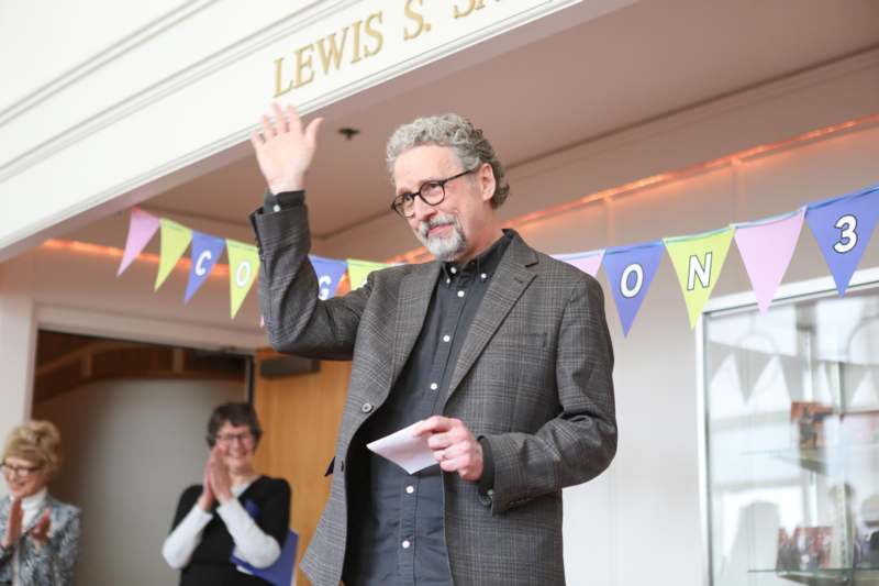 a man in a suit waving