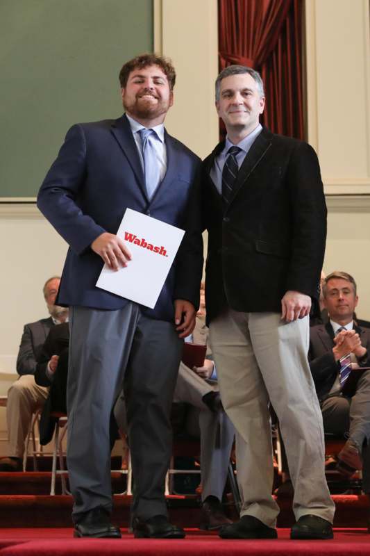 two men standing in front of a crowd