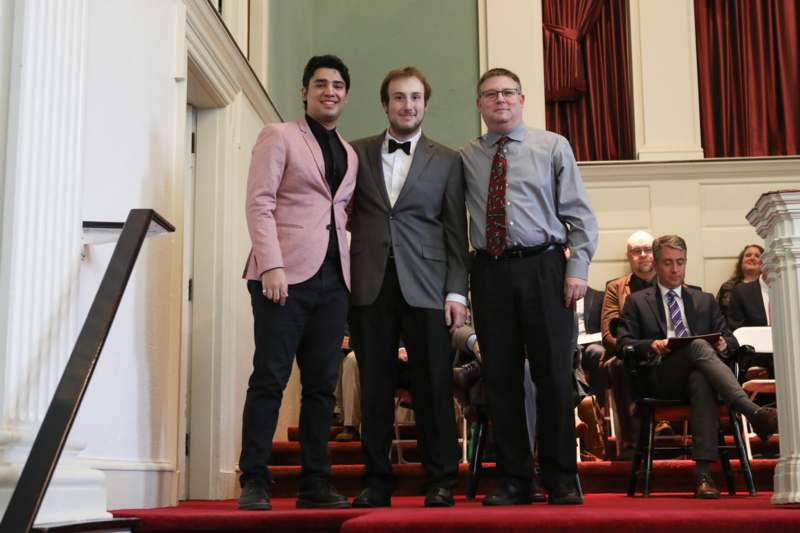 a group of men standing on a red carpet