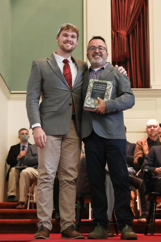 two men standing together and smiling