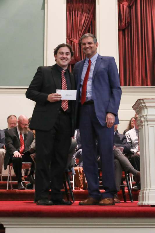 two men standing together in front of a crowd