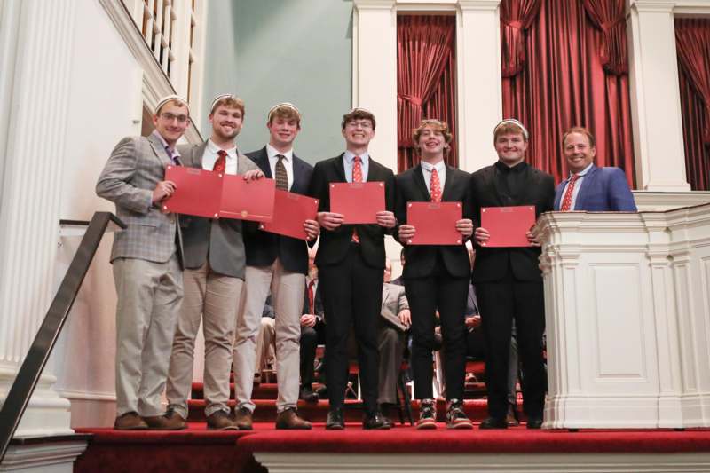 a group of men holding red papers