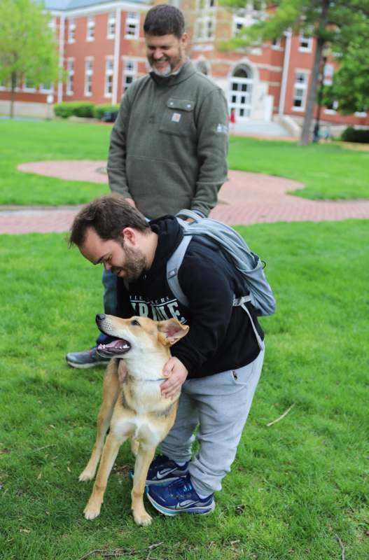 a man petting a dog