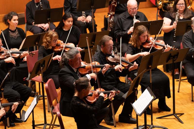 a group of people playing violins