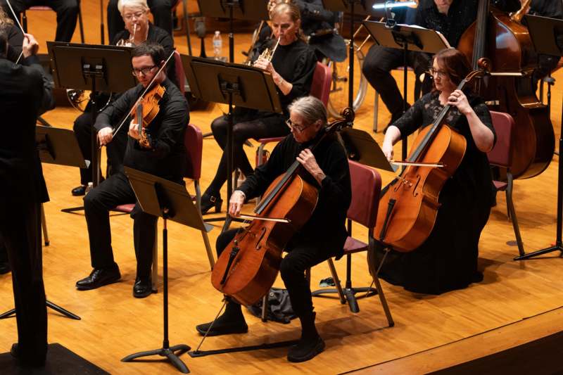 a group of people playing cellos