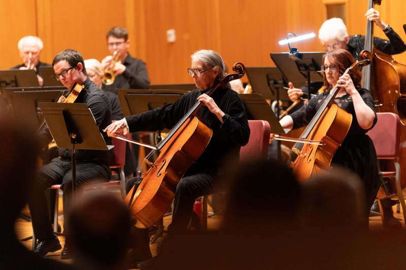 a group of people playing cellos