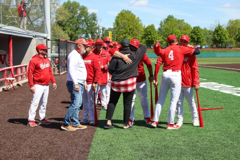 a group of people in red shirts hugging each other