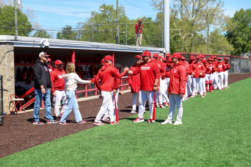 a group of people in red uniforms shaking hands