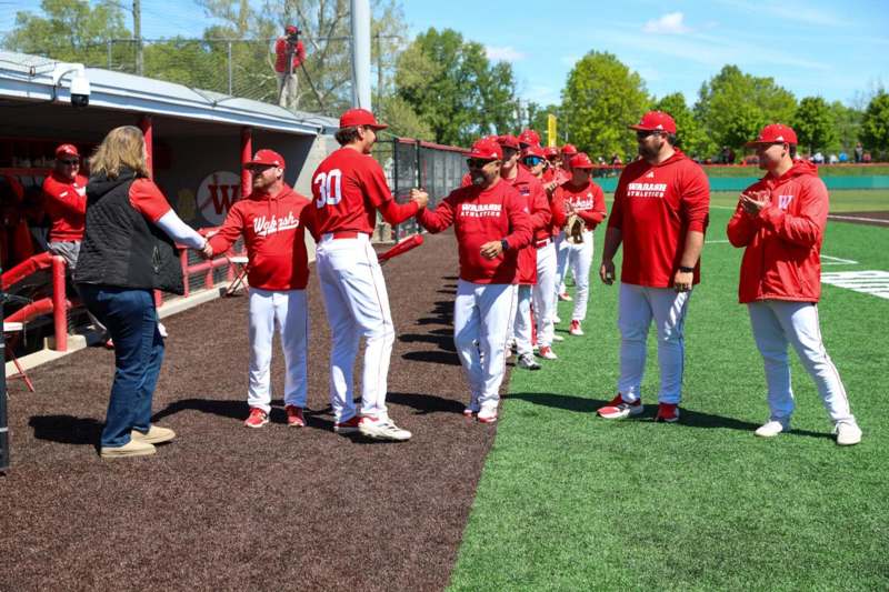 a group of baseball players shaking hands on a field