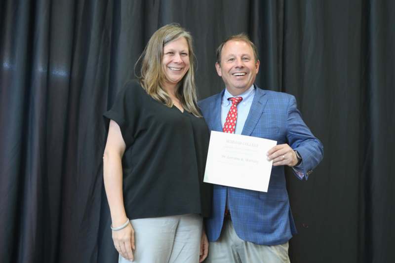 a man and woman holding a piece of paper