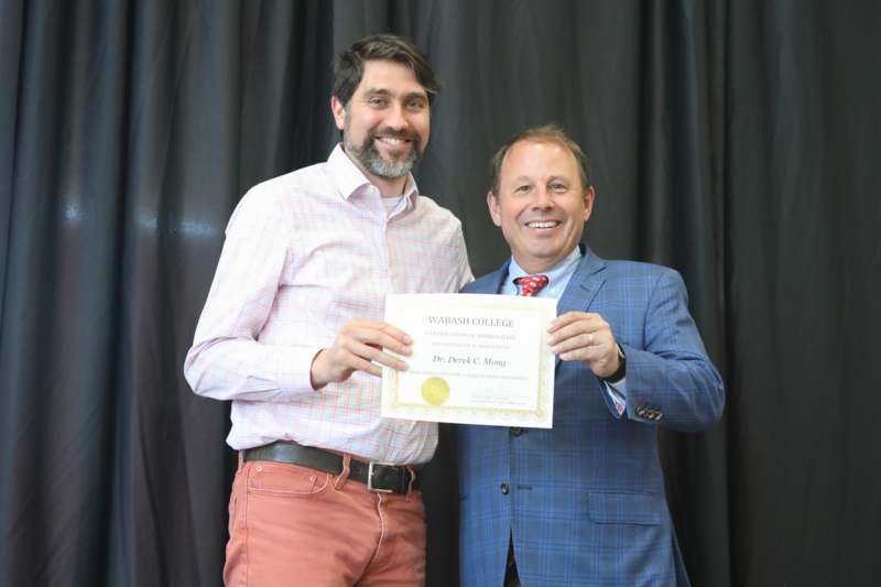 two men holding a certificate