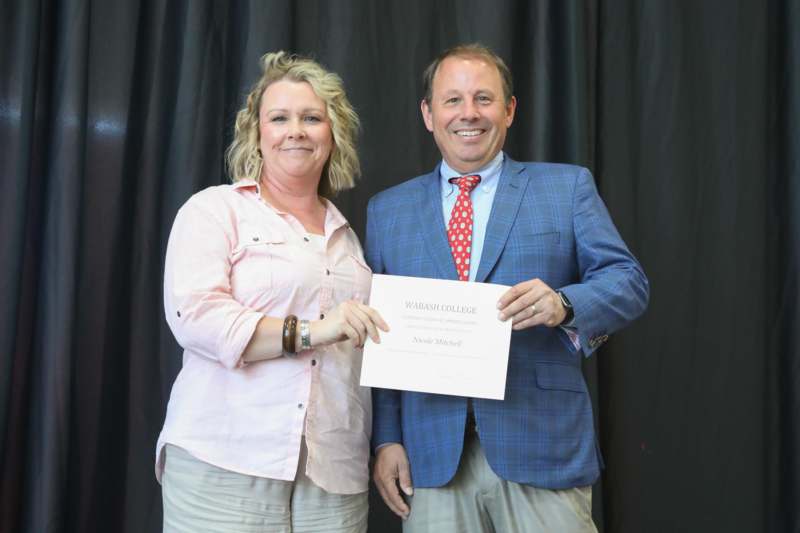 a man and woman holding a certificate