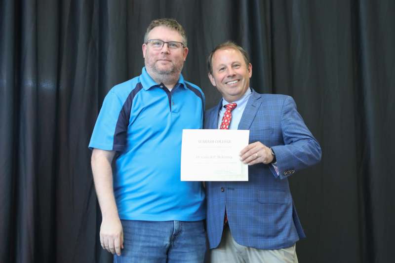 two men holding a piece of paper