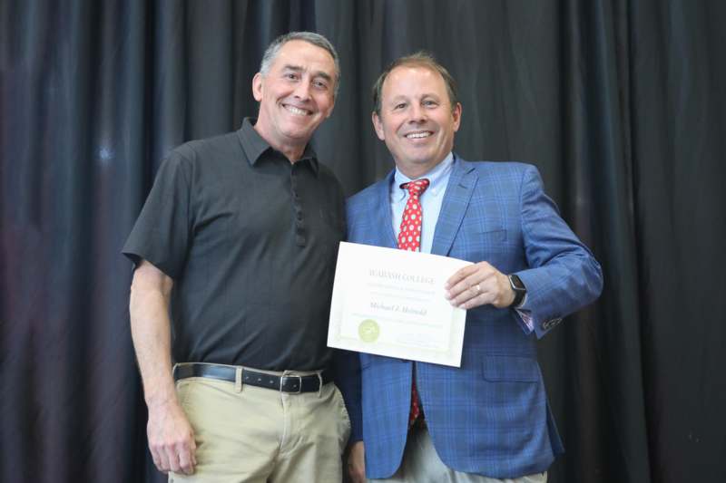 two men holding a certificate