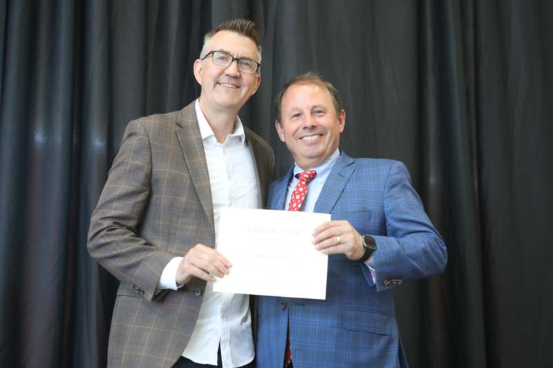 two men holding a piece of paper