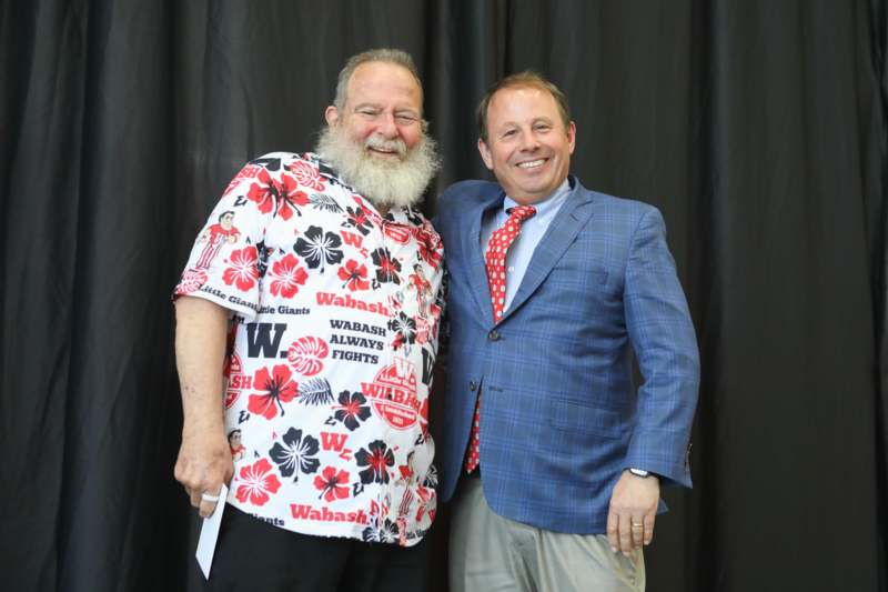 two men standing together smiling