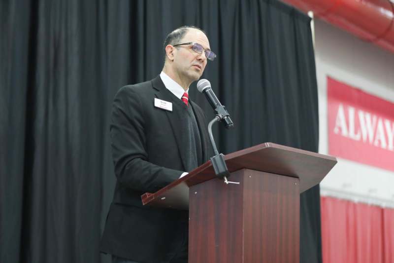 a man standing at a podium with a microphone
