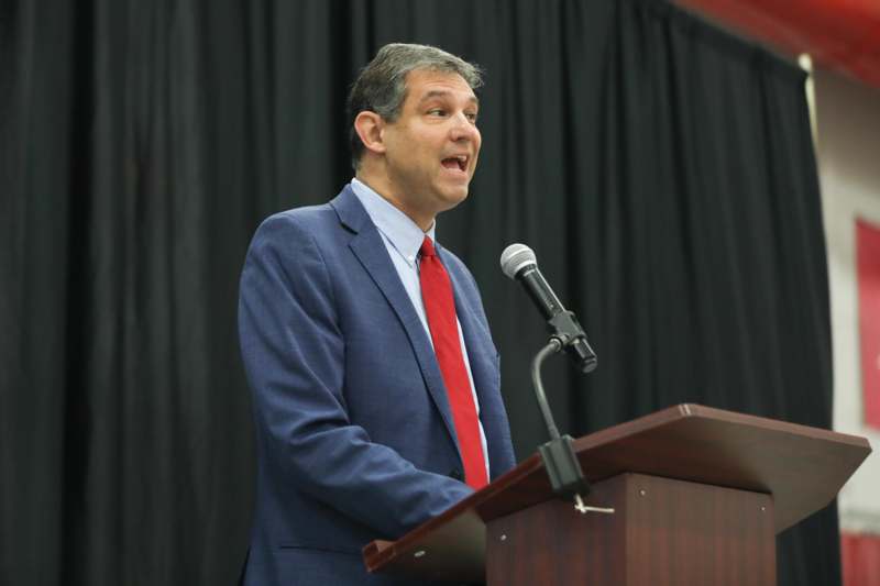 a man standing at a podium with a microphone