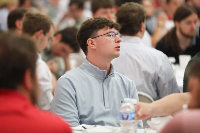 a man sitting at a table with a bottle of water