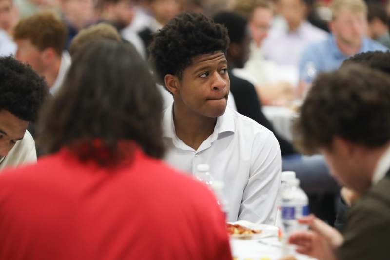 a man sitting at a table with other people in the background