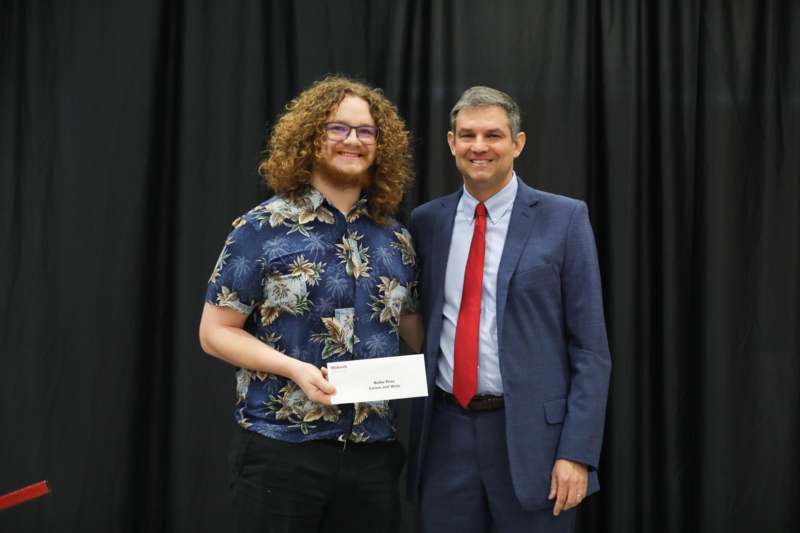 a man holding a piece of paper with a man in a suit