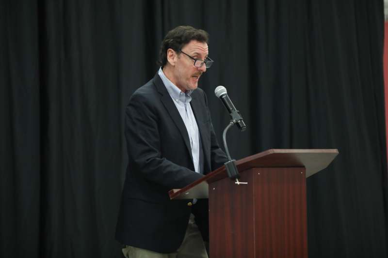 a man standing at a podium with a microphone