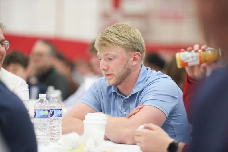 a man sitting at a table with a bottle of water