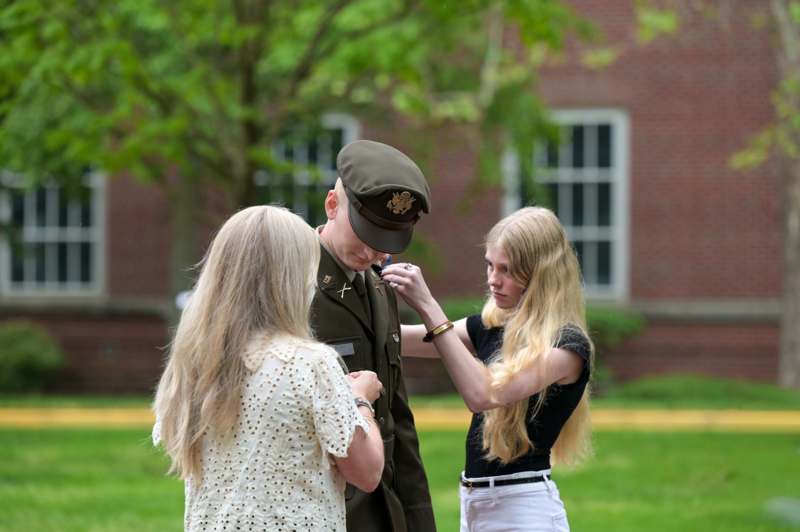 a man in a military uniform with two women in front of him