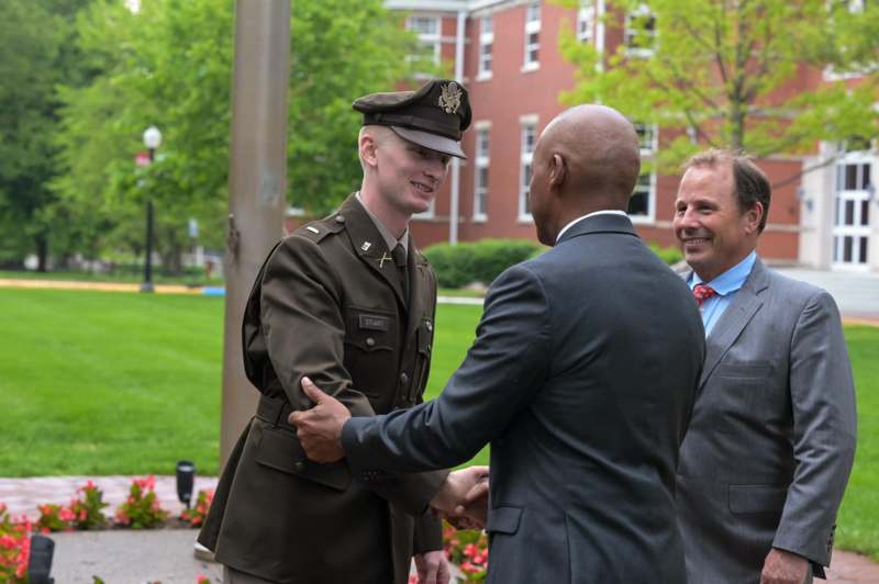 a man shaking hands with a man in a uniform
