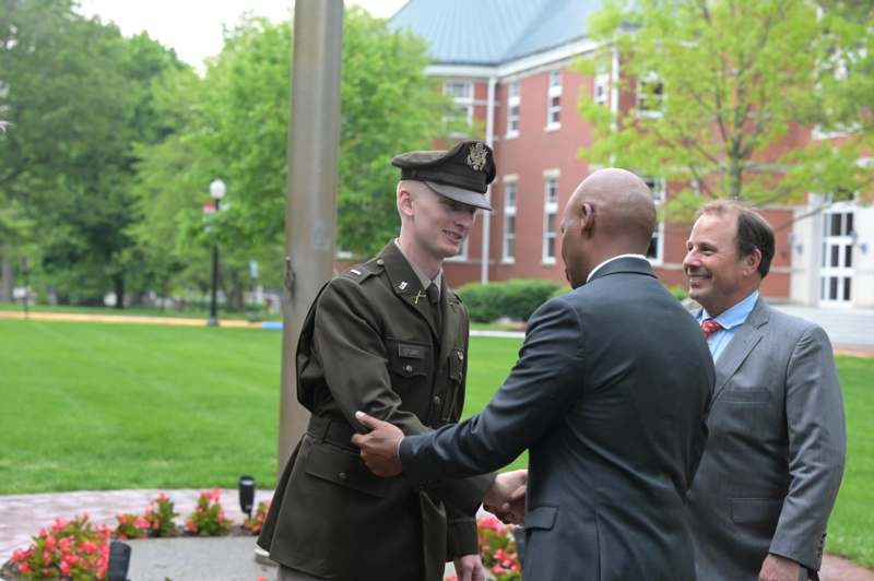 a man shaking hands with a man in a uniform