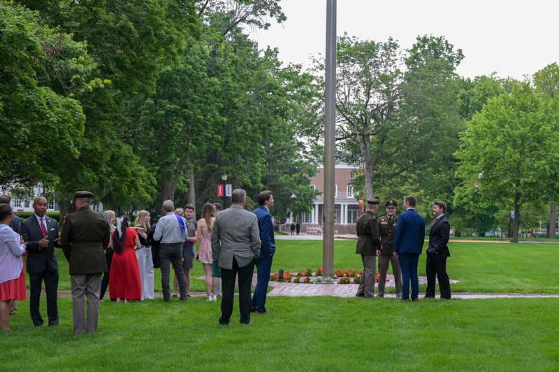 a group of people standing in a circle in front of a flag pole