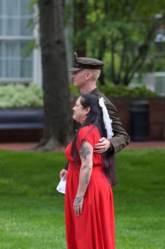 a man in a uniform holding a woman in a red dress