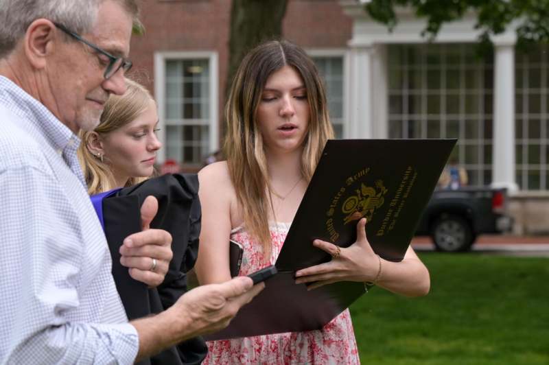 a man and woman looking at a folder