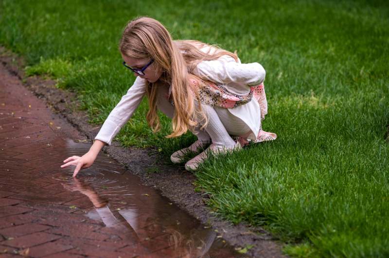a girl touching a puddle of water