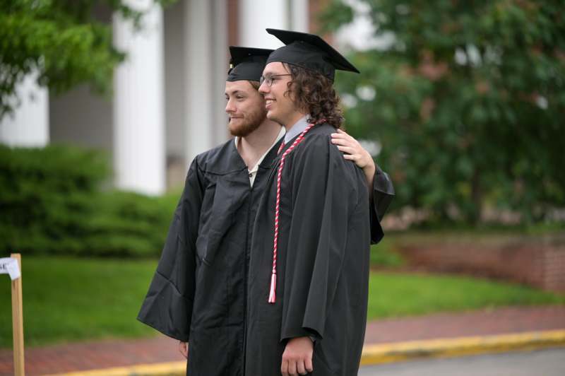 a man in a cap and gown hugging another man