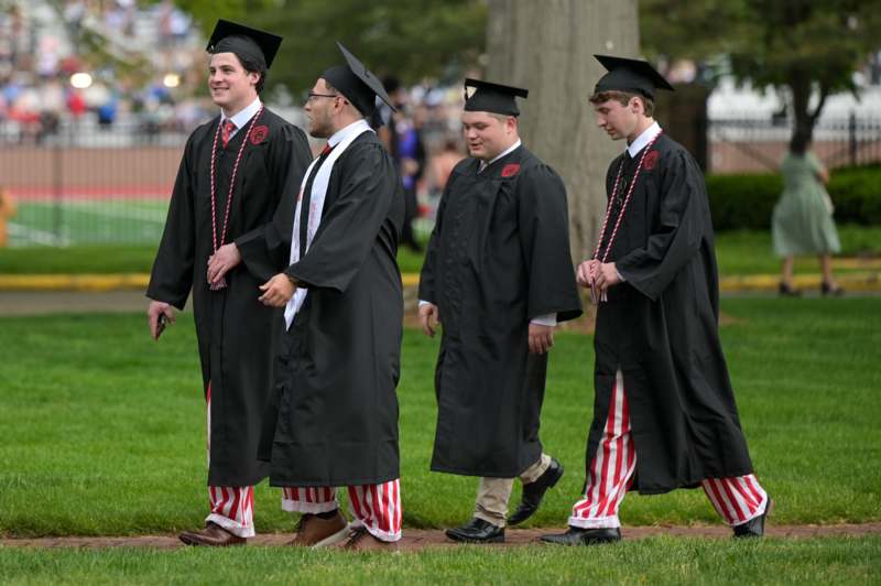 a group of men in graduation gowns and caps