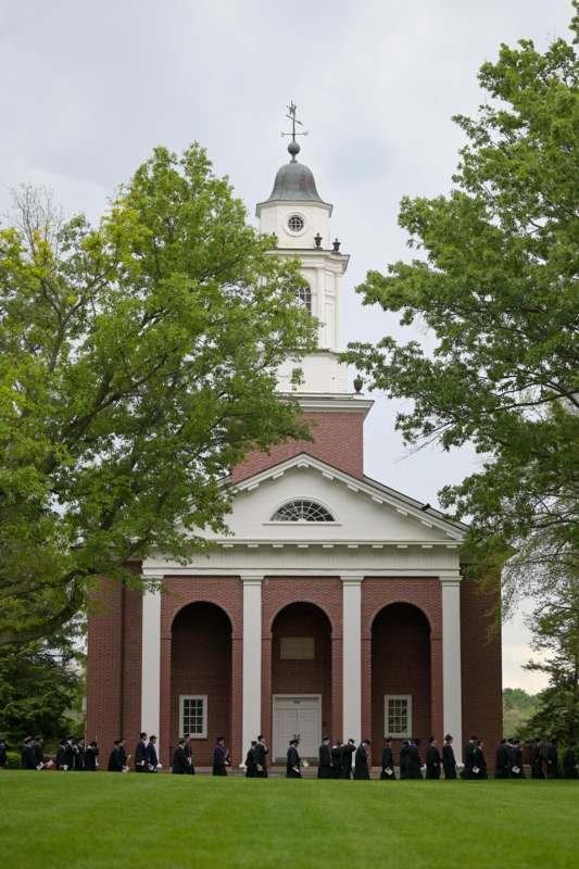 a brick building with a tower and a tree