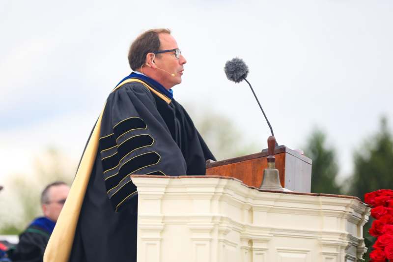 a man in a robe standing at a podium