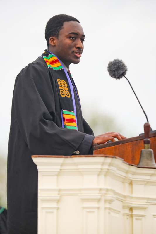 a man in a robe standing at a podium