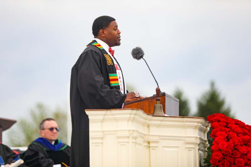 a man in a robe speaking into a microphone