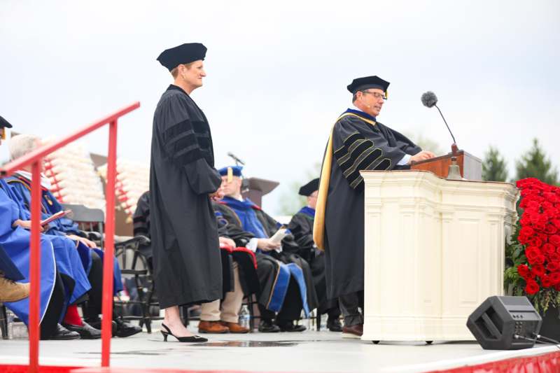 a man and woman in black robes standing at a podium