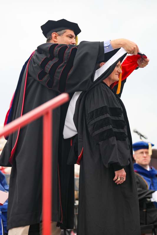 a man in a black robe holding a woman's head