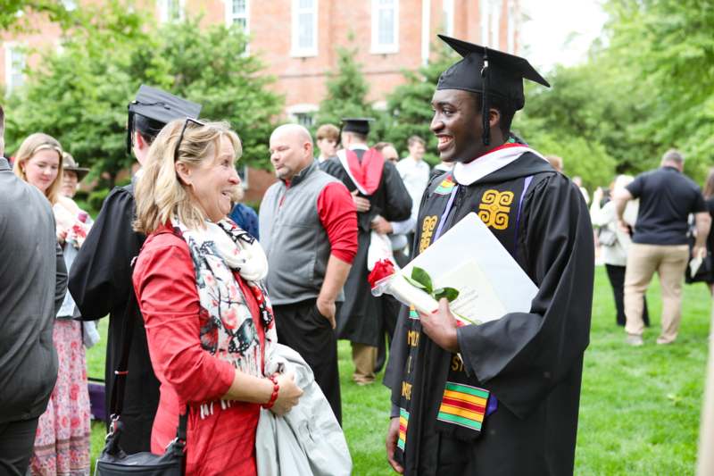 a man in a cap and gown talking to a woman