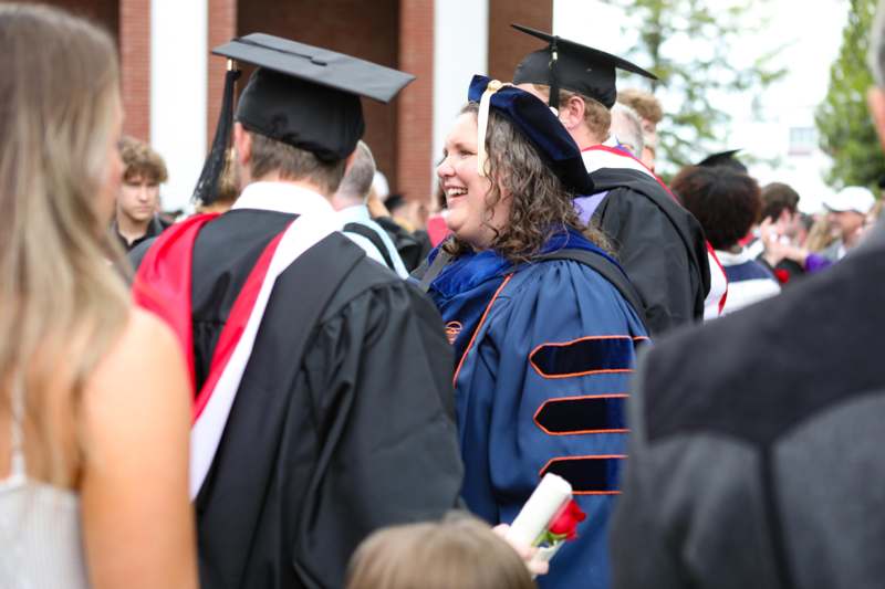 a woman in graduation gowns and cap and gowns