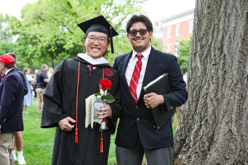 two men in graduation gowns and cap and gowns