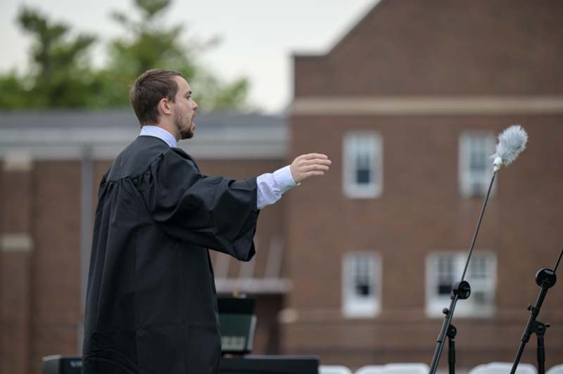 a man in a robe speaking into a microphone