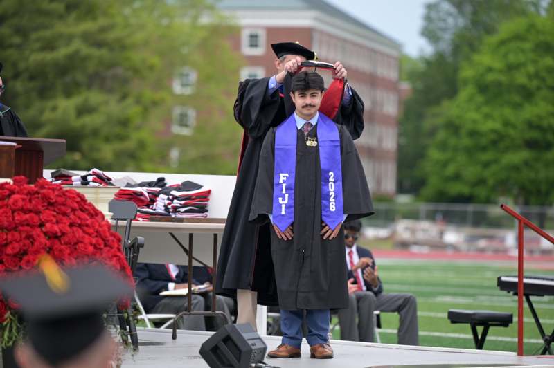 a man wearing a graduation gown and cap
